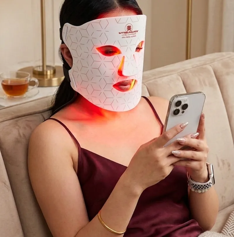Mujer usando la máscara Luxon Skin mientras mira el móvil